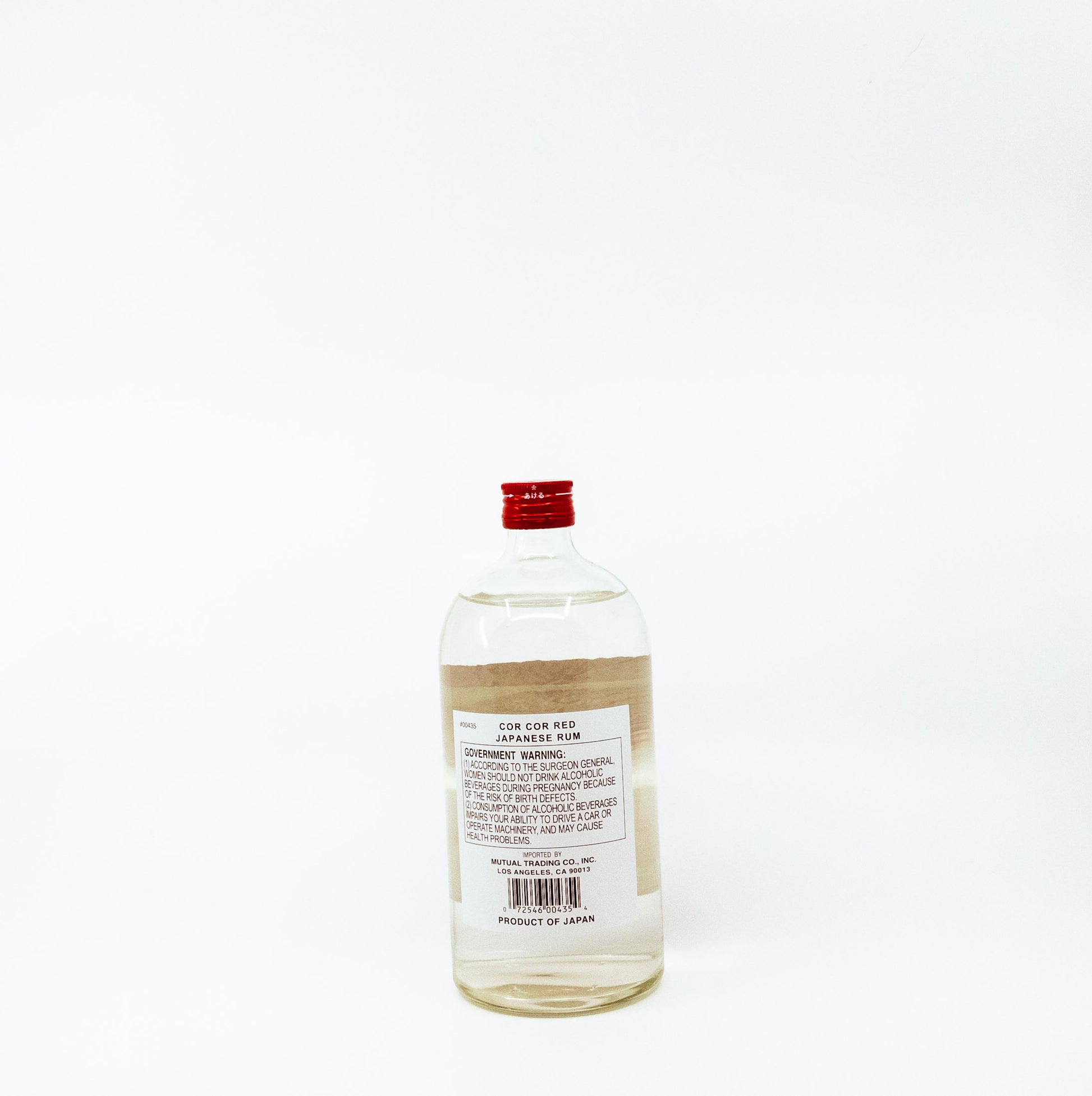 back of short glass bottle with red cap and label