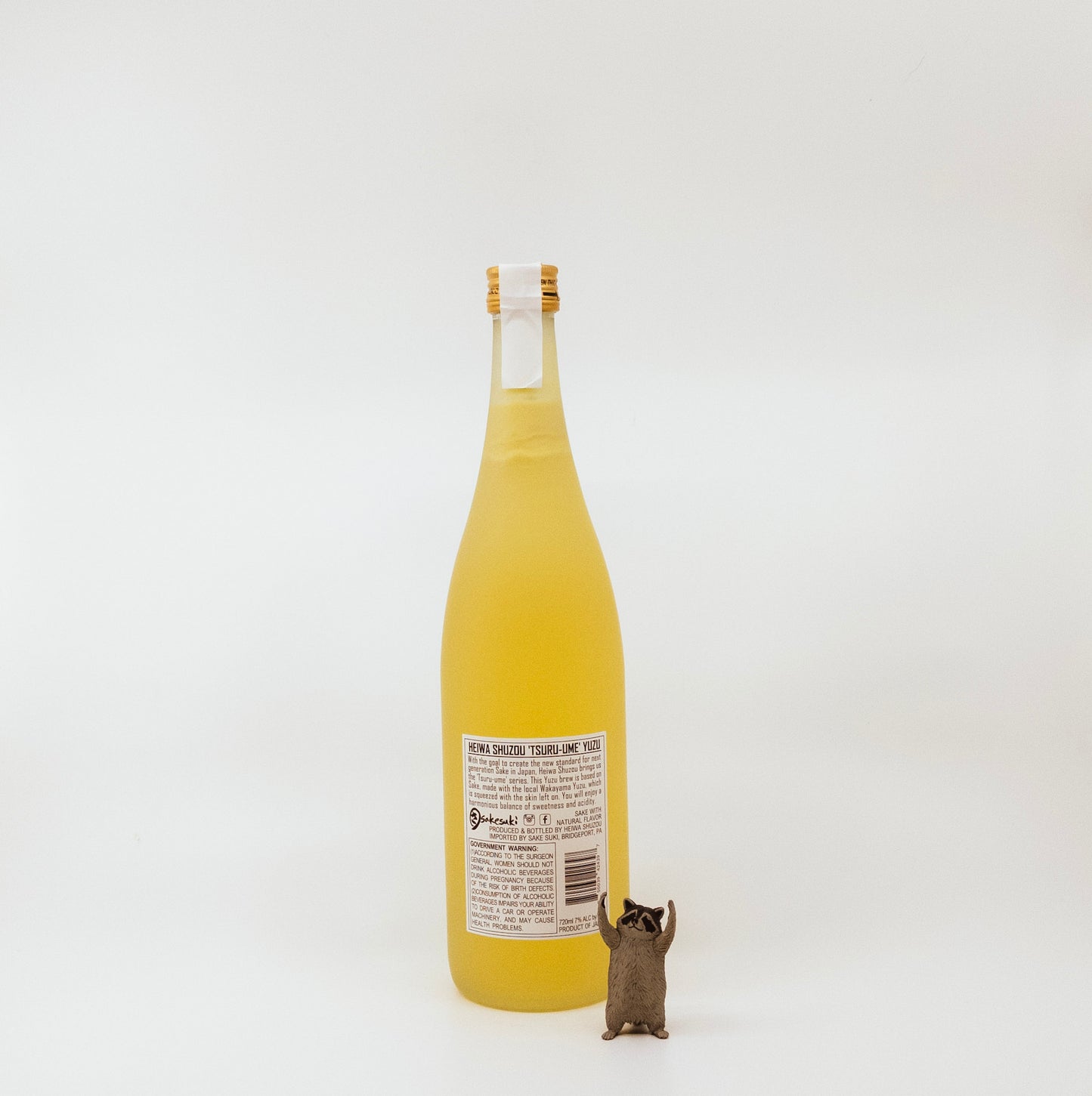 back of yellow bottle with raccoon figurine