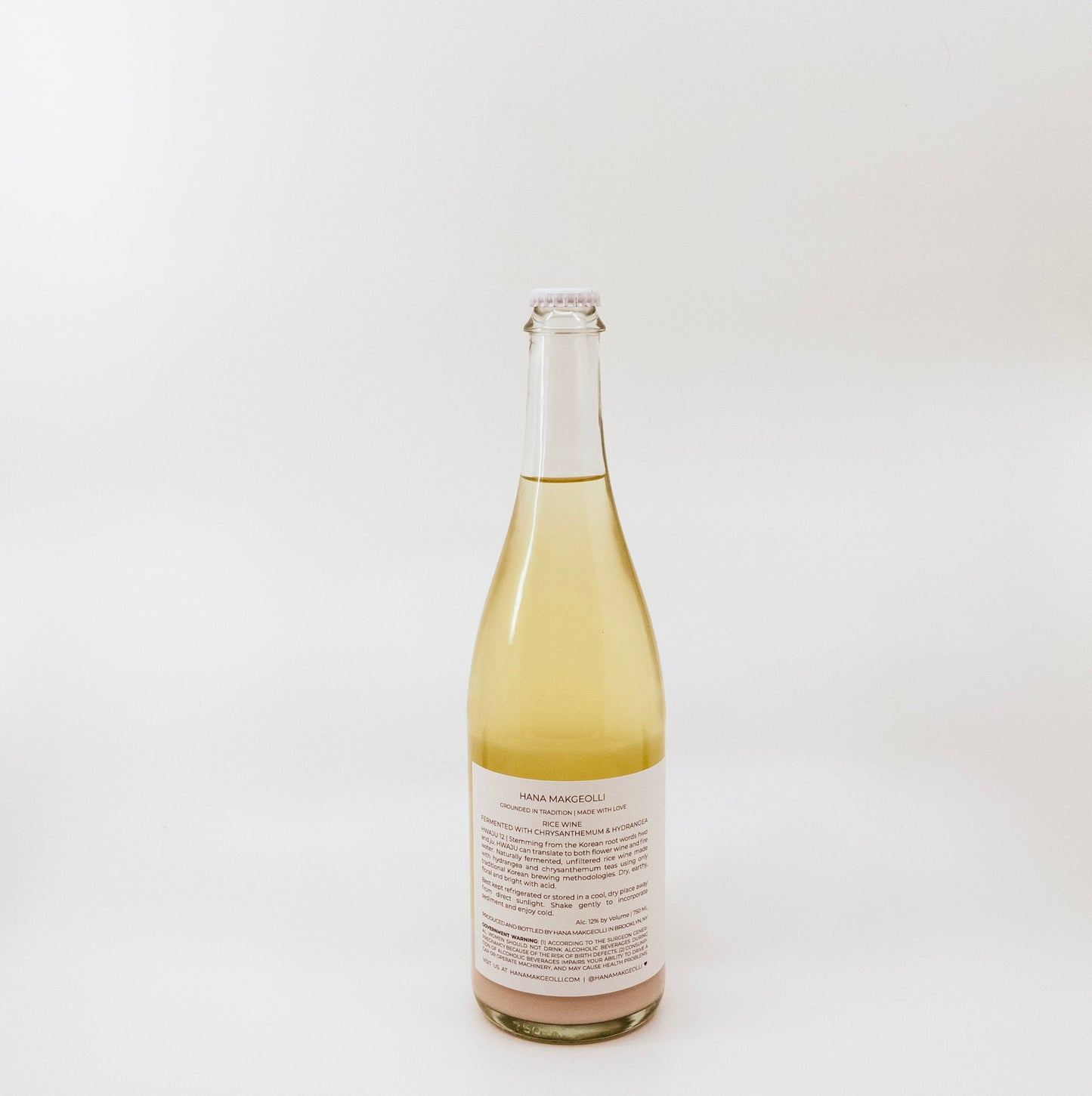 back of light yellow glass bottle with white label