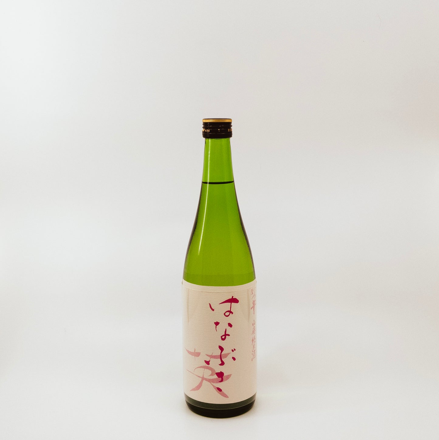 green glass bottle with red writing on cream label