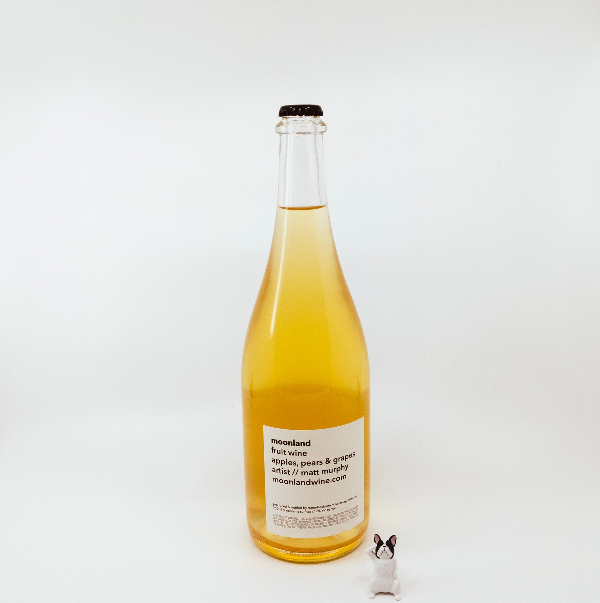 back of yellow glass bottle with sunset on circle logo