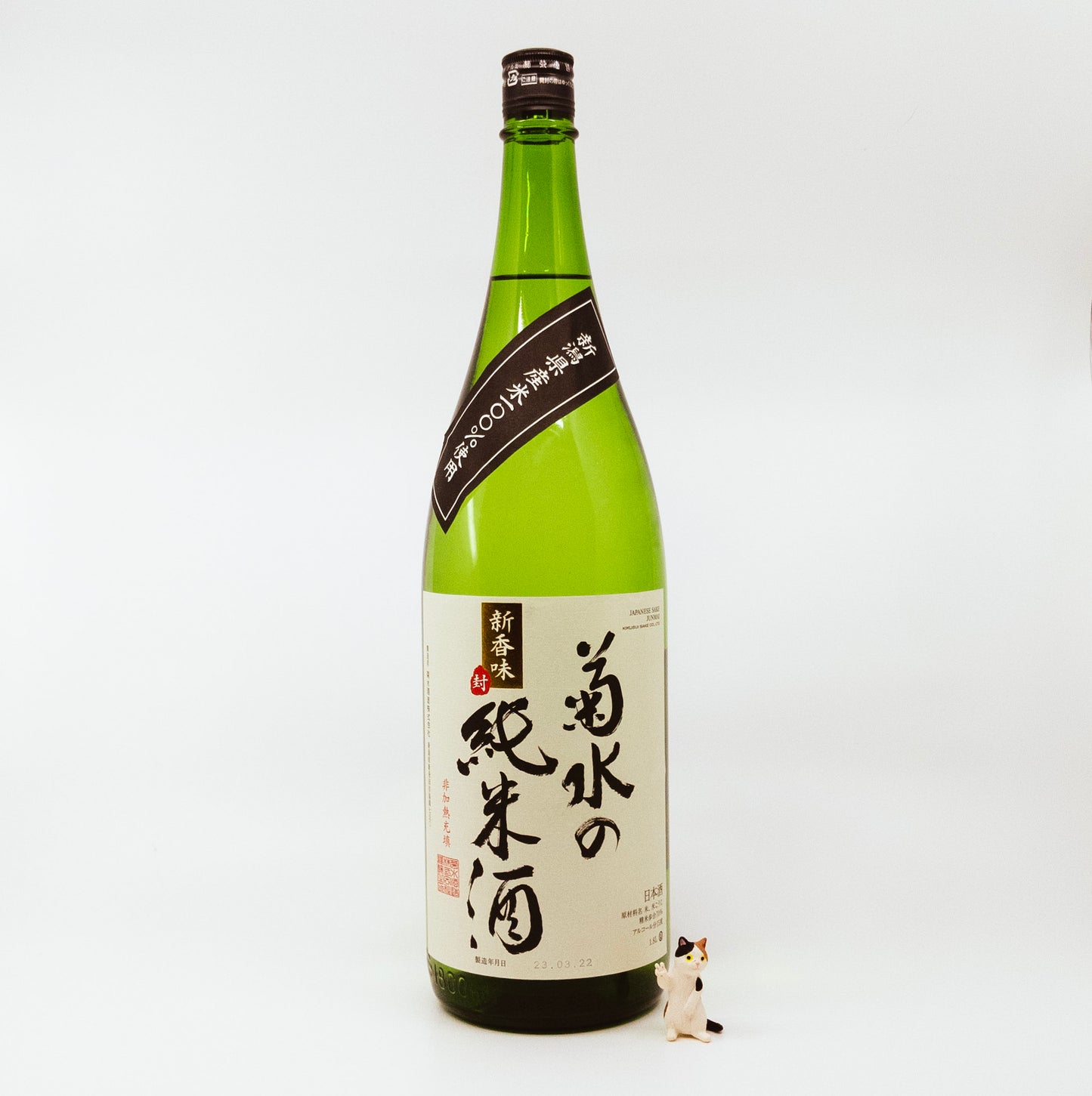 green bottle with cream label next to cat figurine