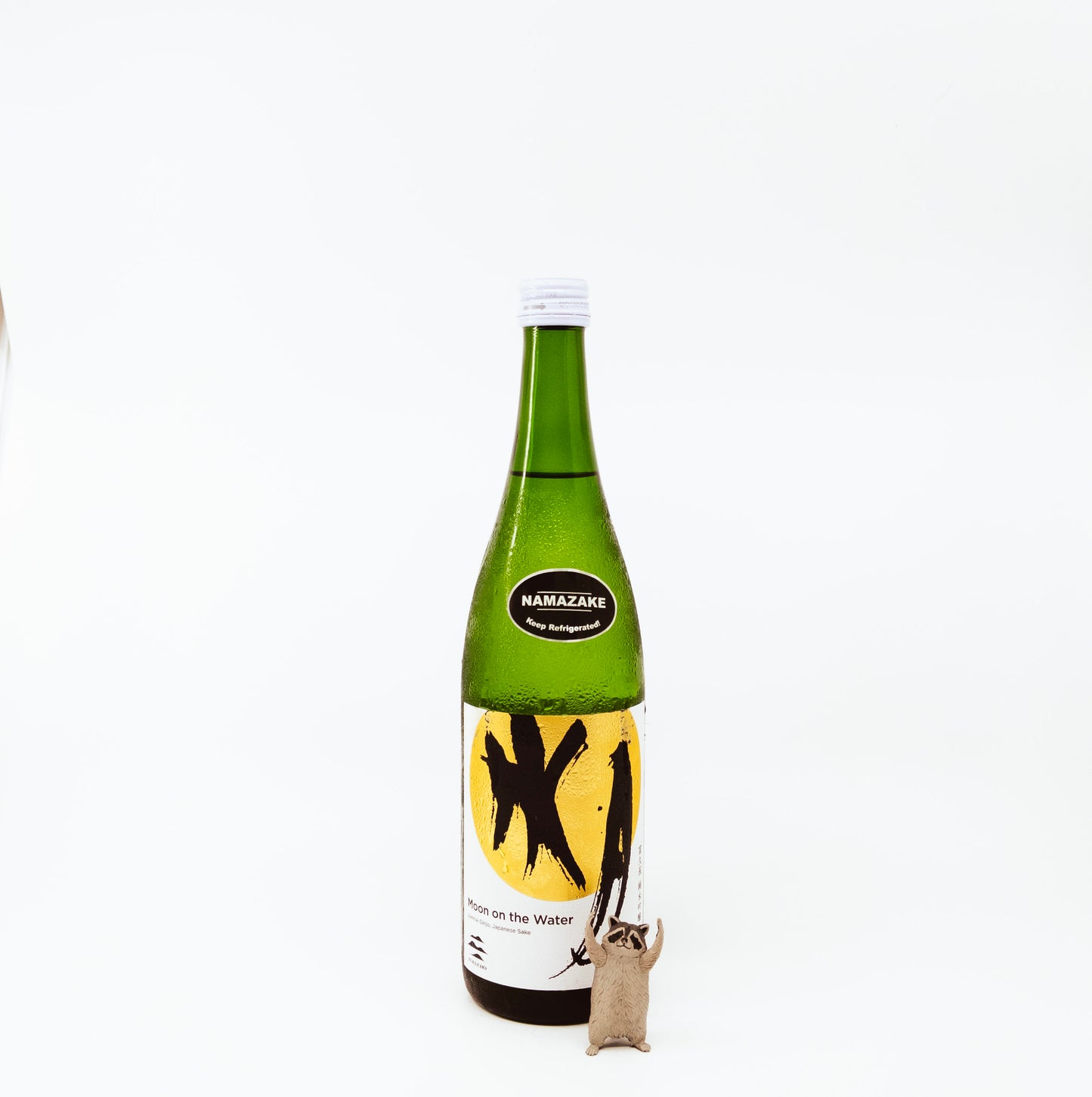 glass bottle next to raccoon figurine