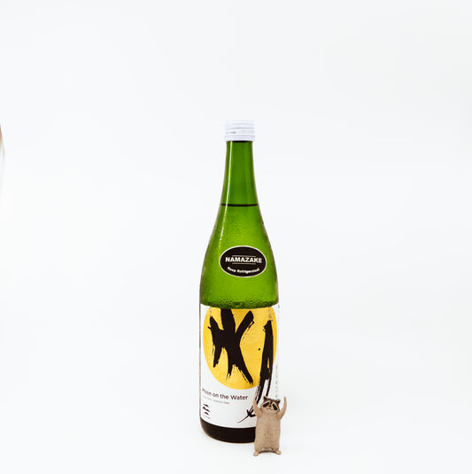 glass bottle next to raccoon figurine