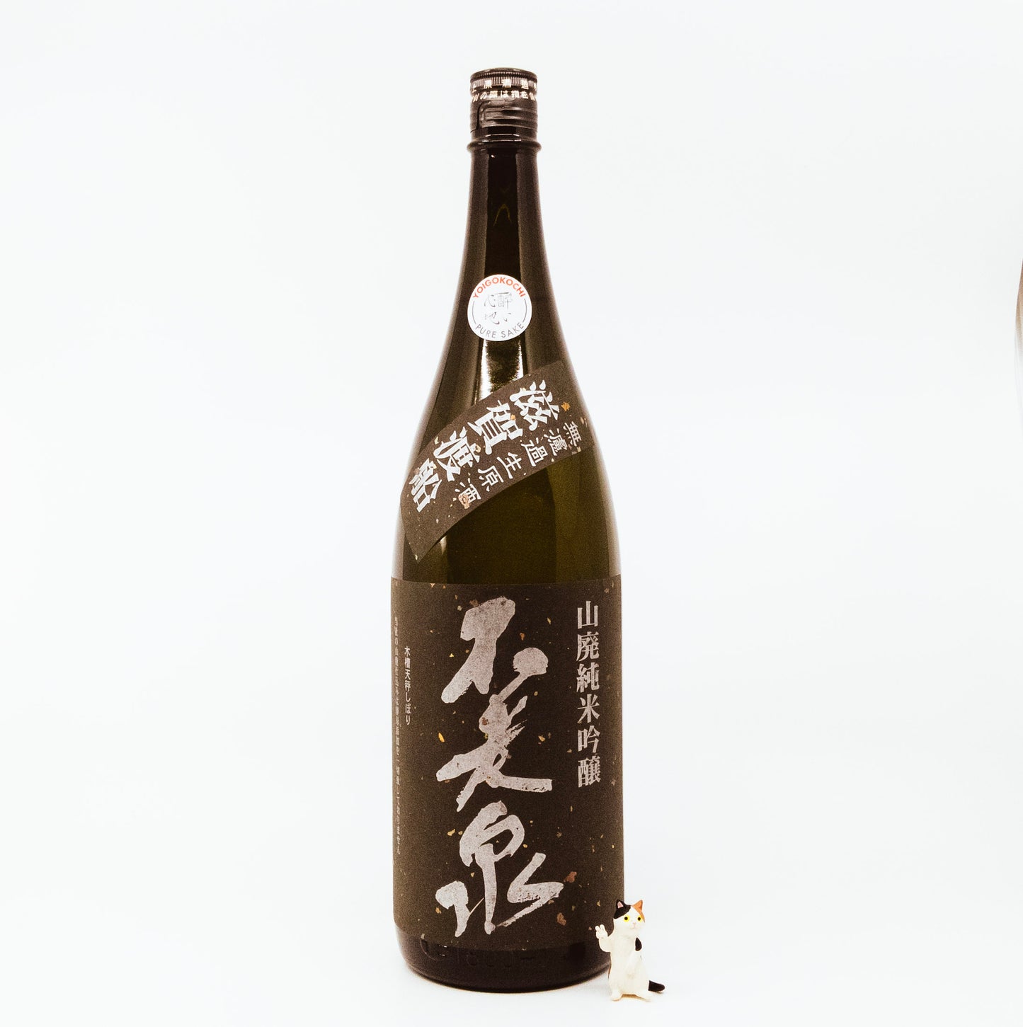 brown glass bottle with cat figurine next to it