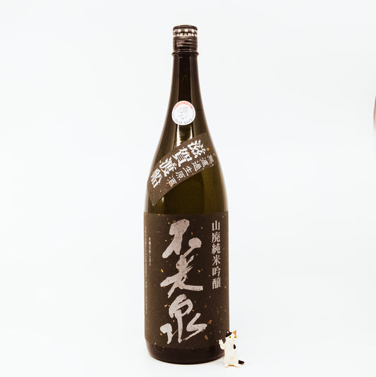 brown glass bottle with cat figurine next to it