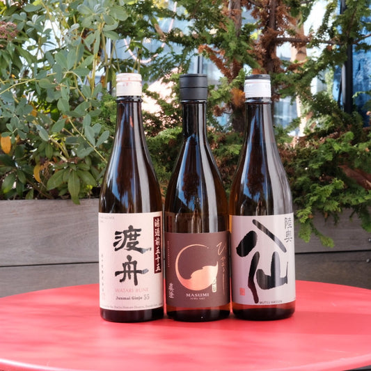 three bottles of wine on red table