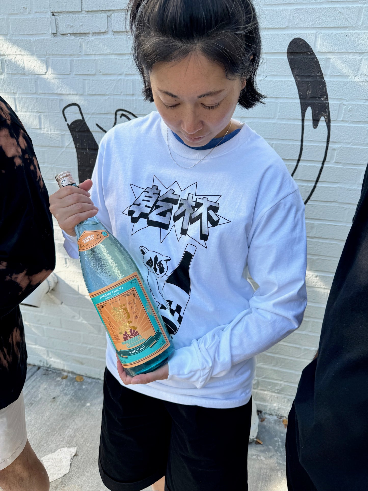 woman in white shirt holding wine bottle