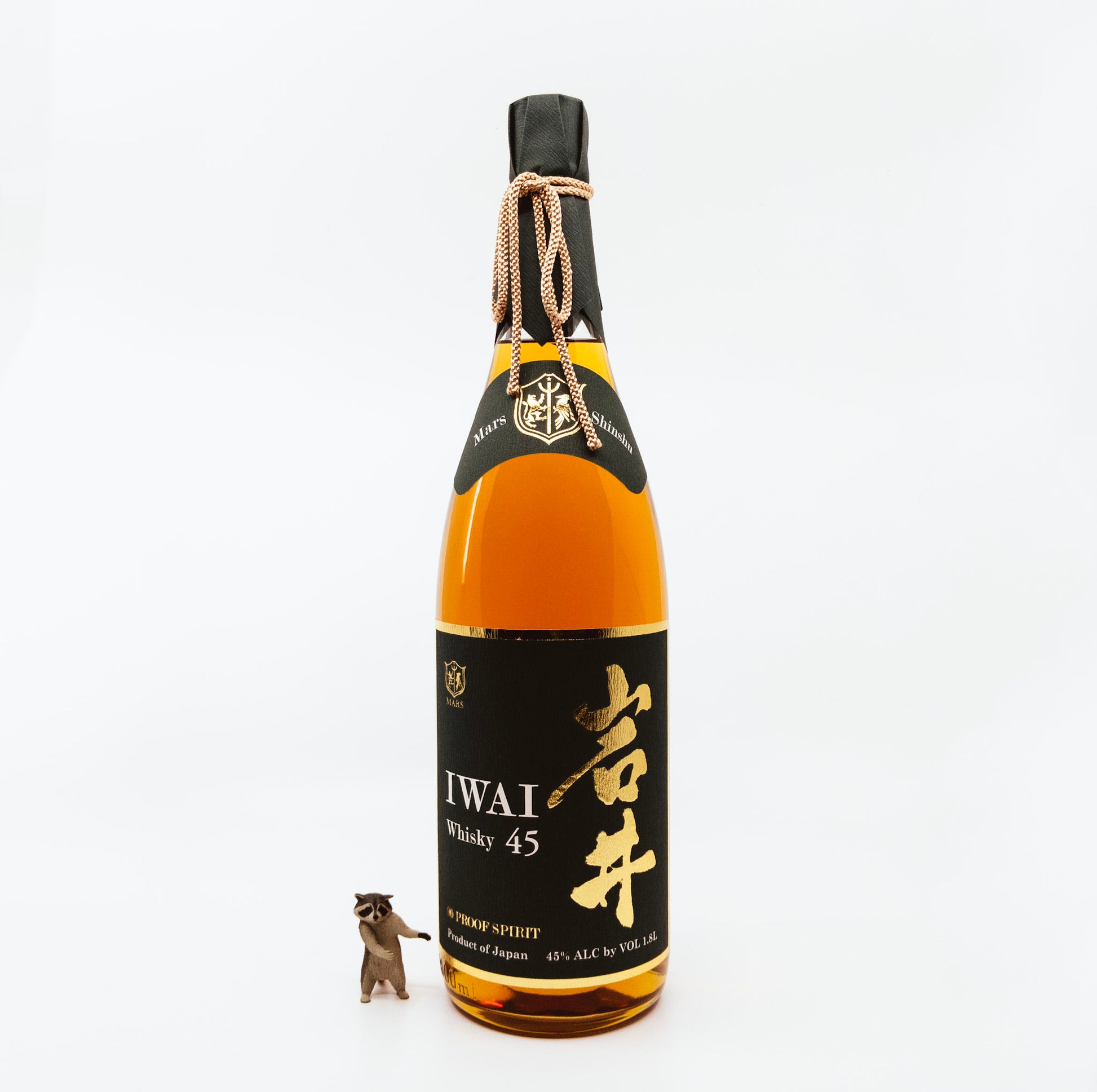 bottle of iwai whisky next to raccoon figurine