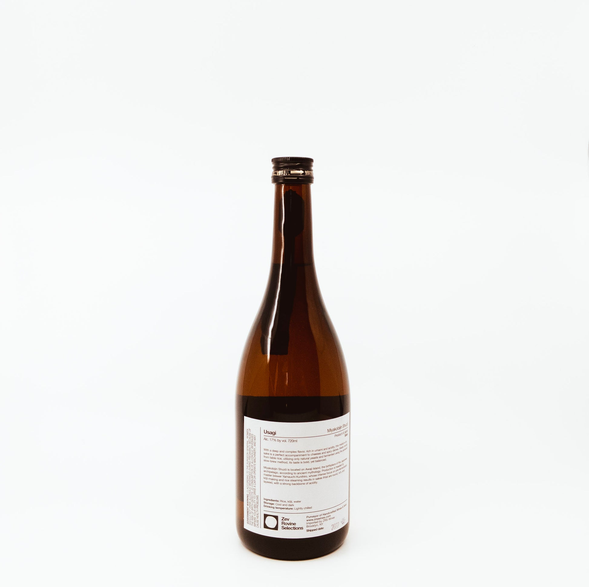 back of glass bottle with red feathers on label
