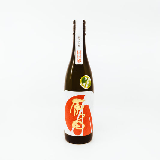 dark bottle with gold writing and red shapes on white label