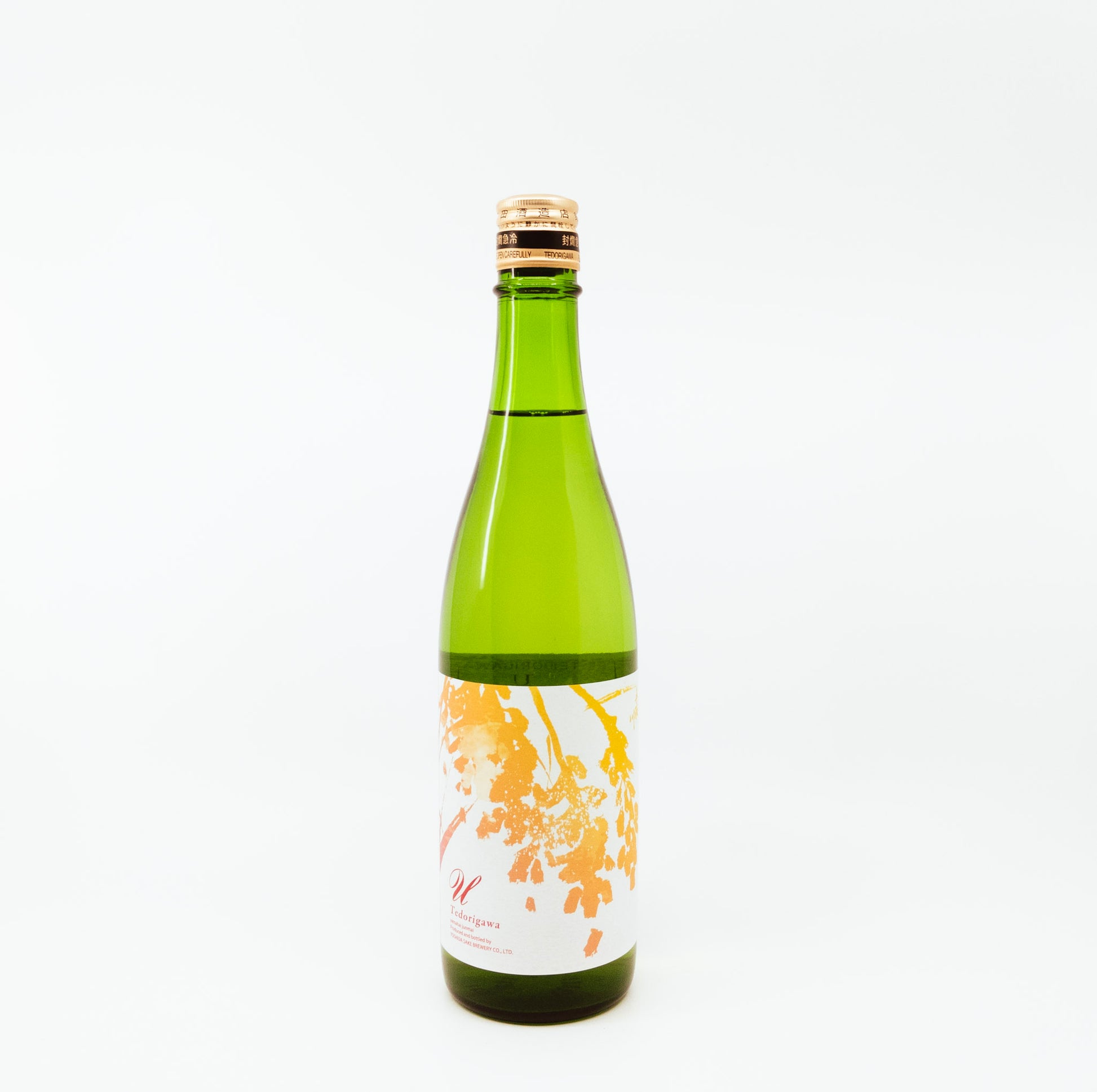 green bottle with gold leaves on white label