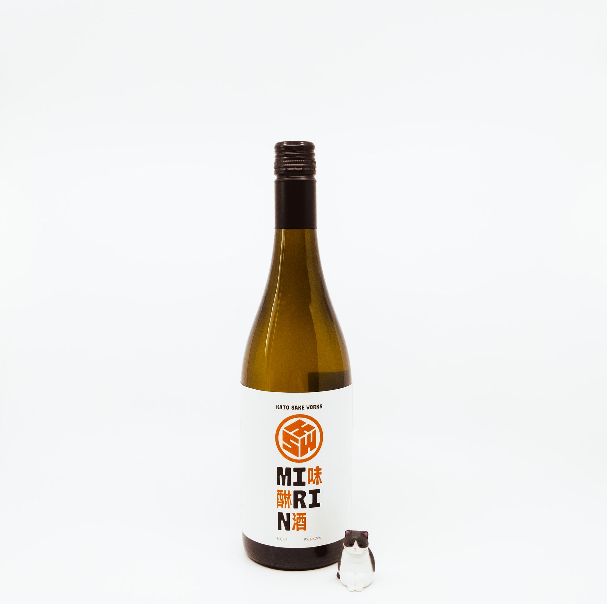 bottle with orange logo on label next to cat figurine