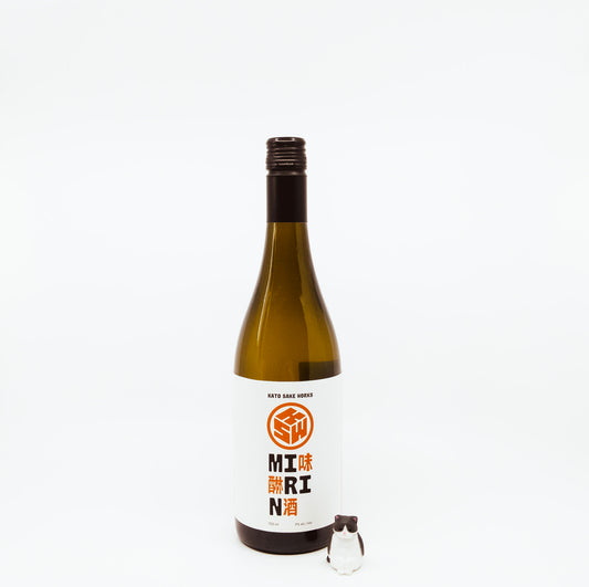 bottle with orange logo on label next to cat figurine