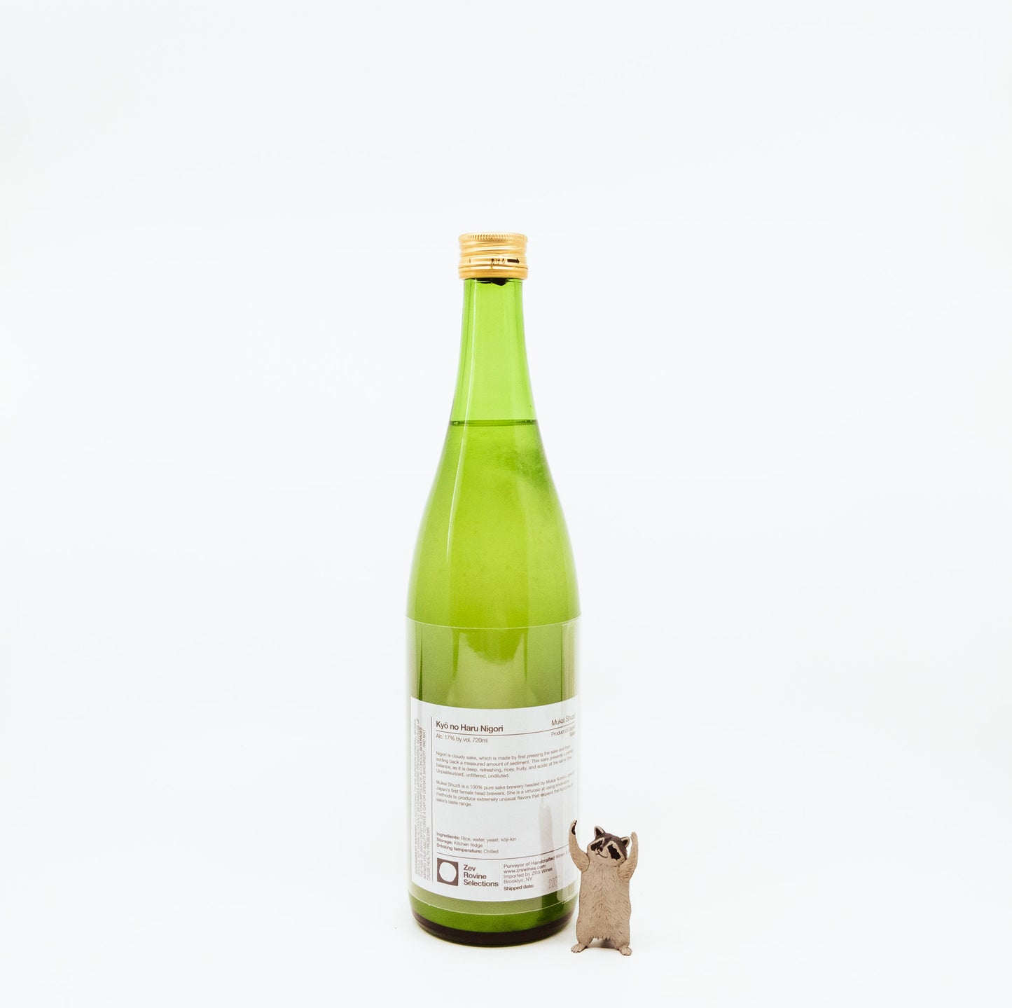 back of green bottle next to raccoon figurine