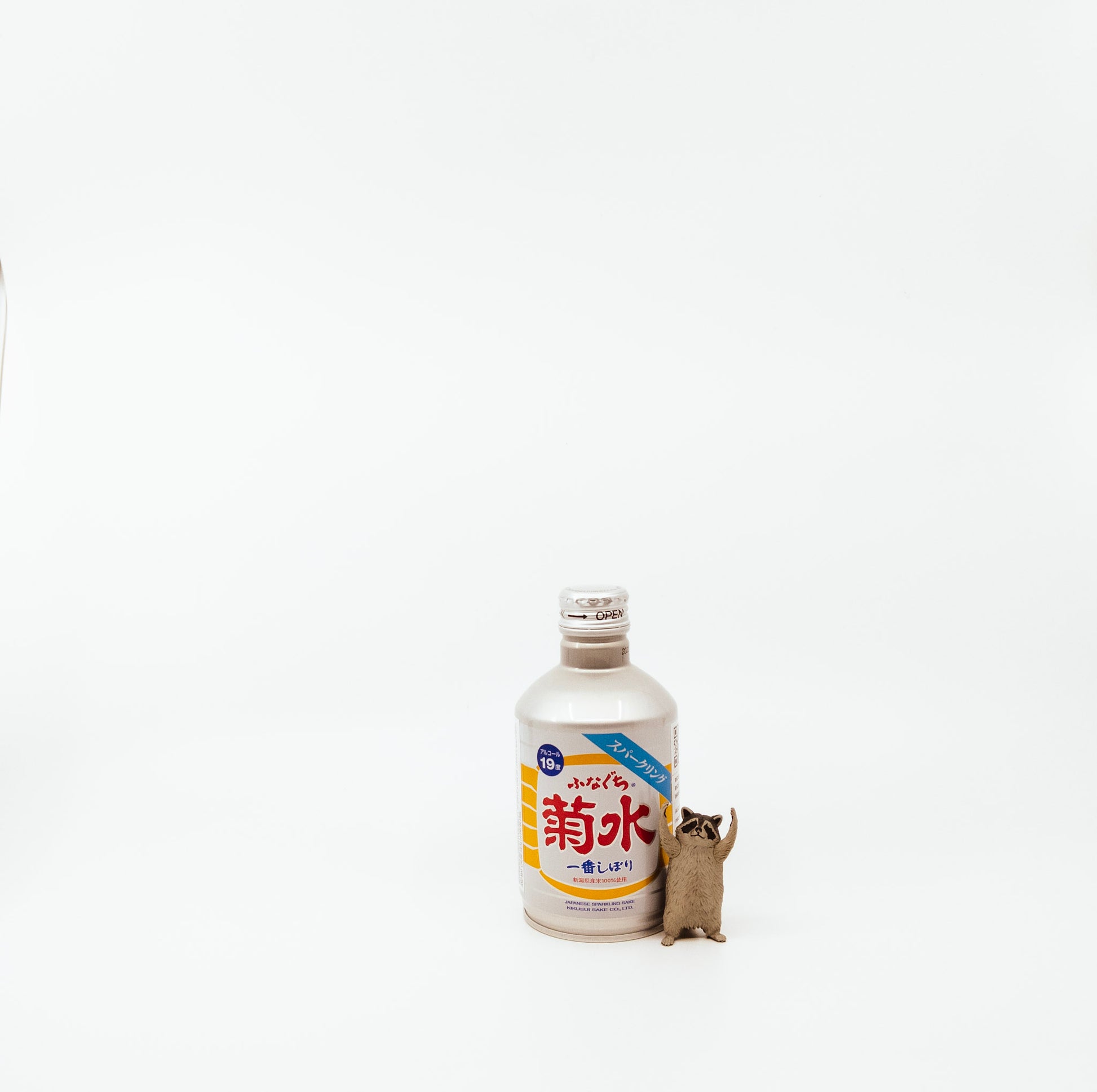 small white bottle next to raccoon figurine