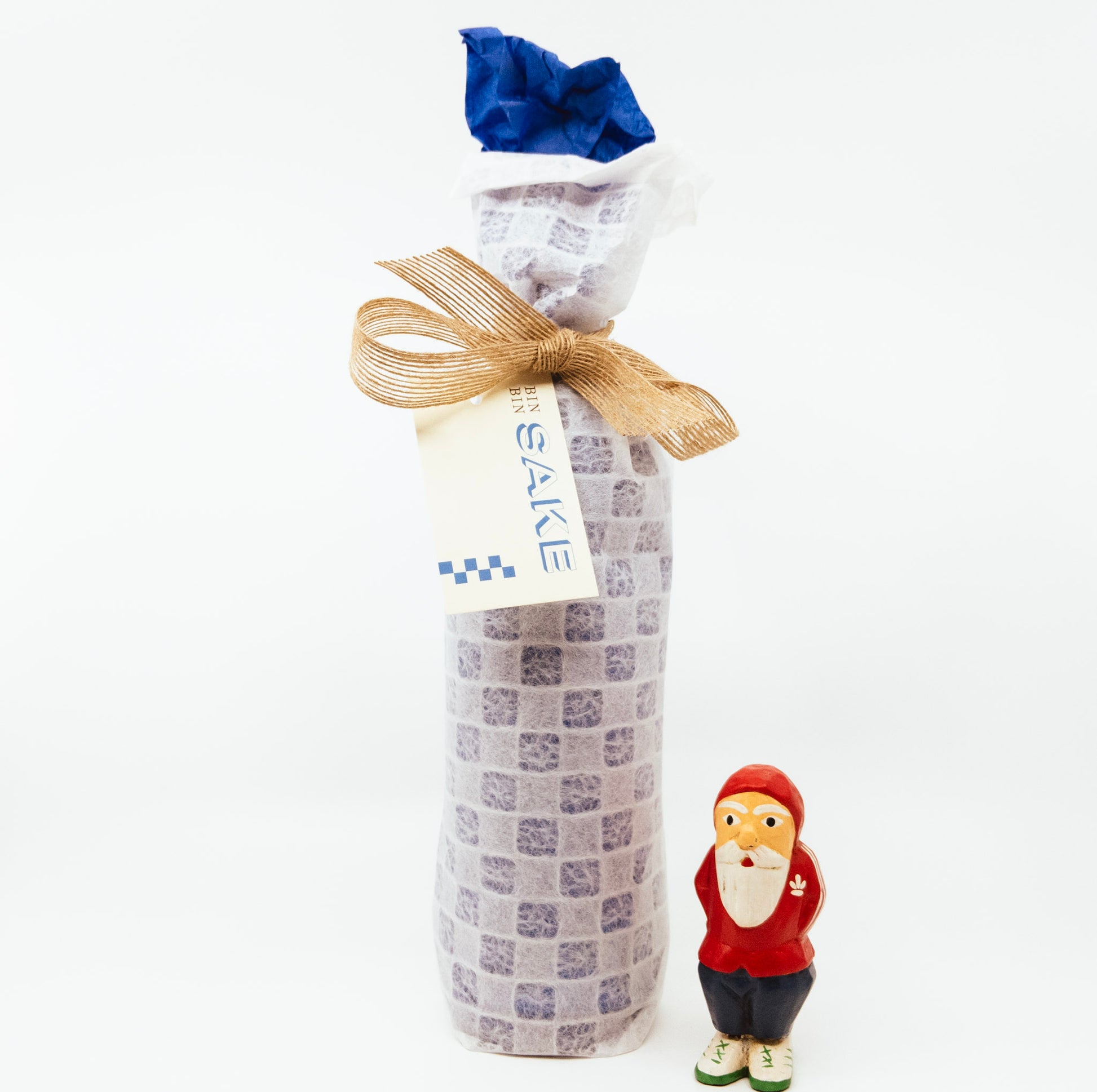 santa figurine next to wrapped bottle of wine