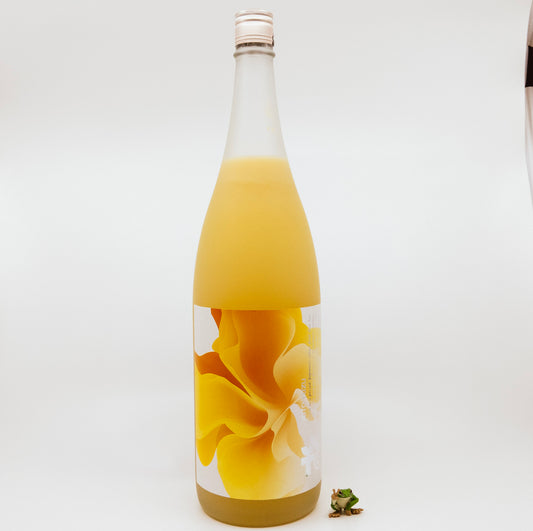 orange bottle with orange flower on label next to frog figurine