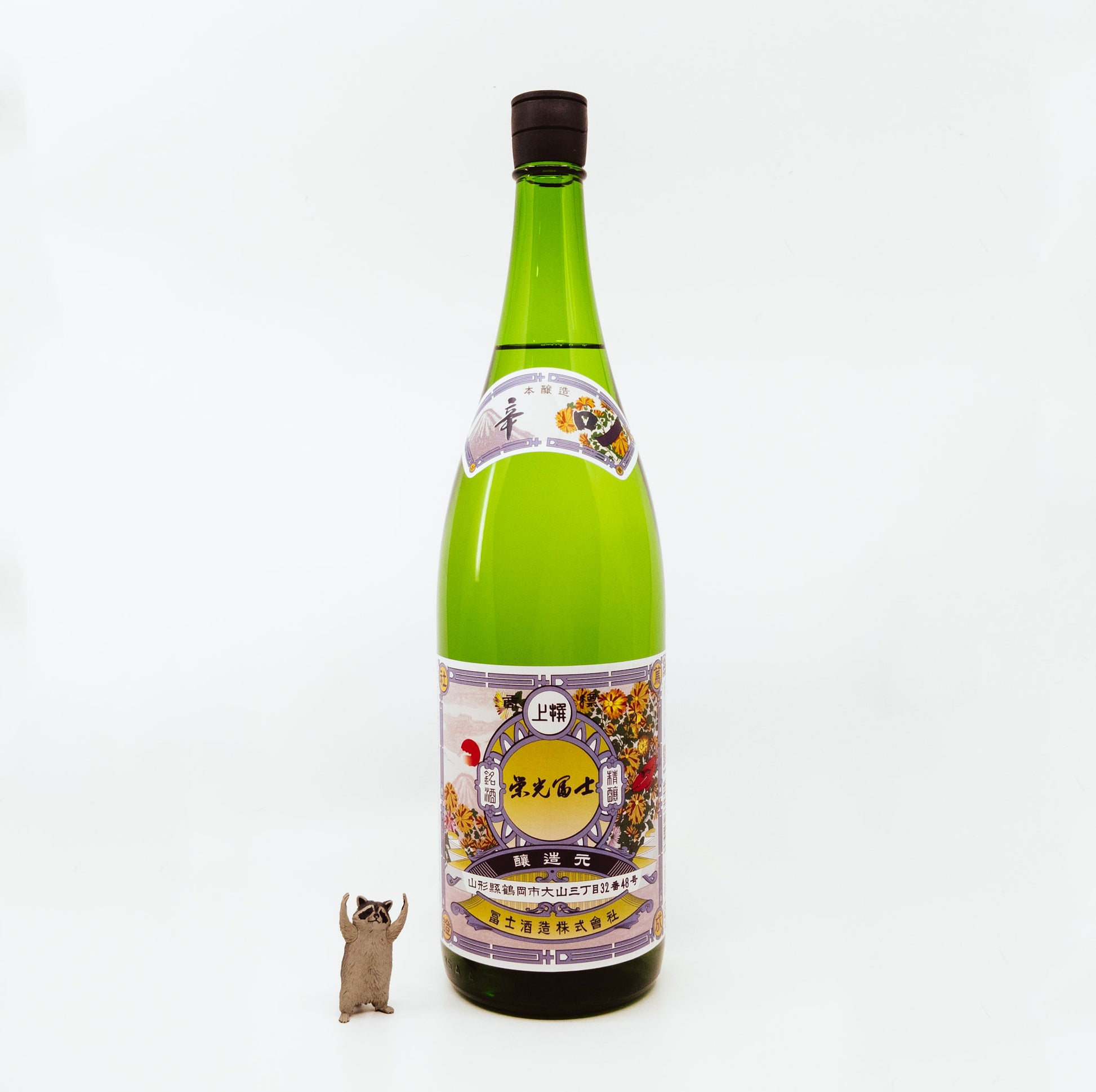 green bottle next to raccoon figurine