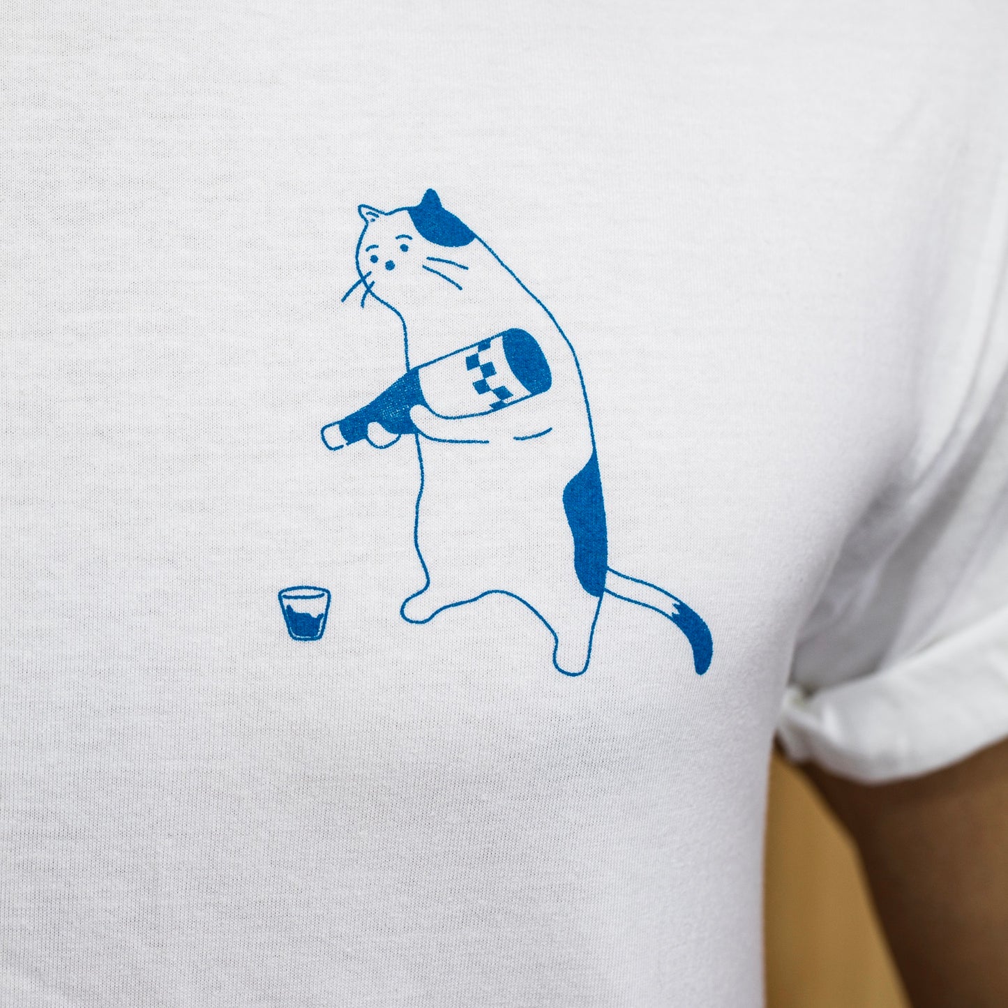 close up of white t shirt with blue outline of cat pouring wine in glass