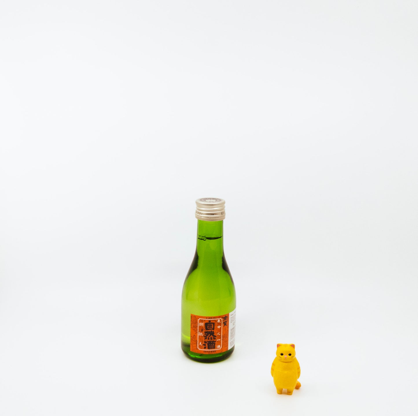 small green bottle near cat figurine
