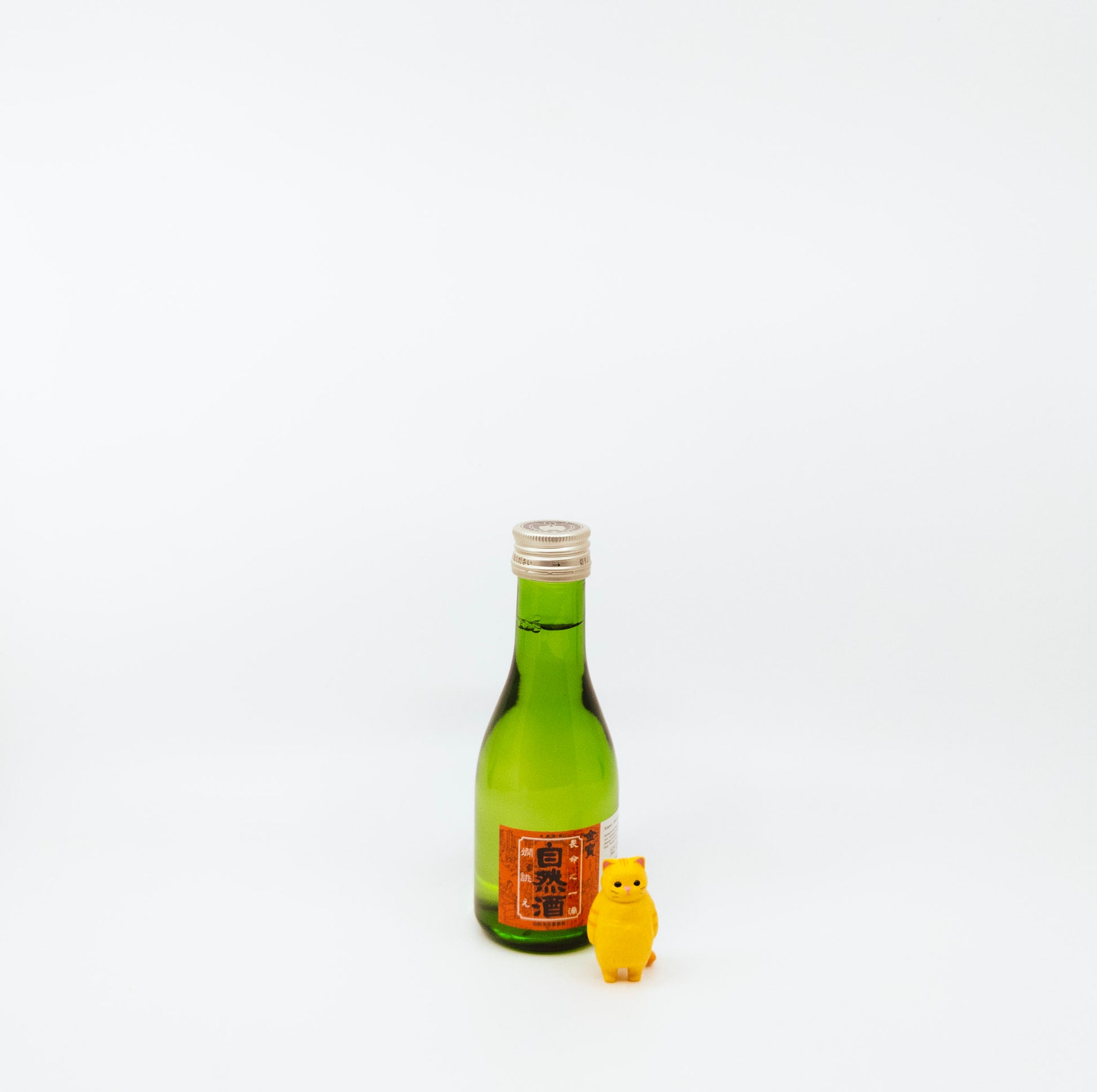 small green bottle with cat figurine next to it