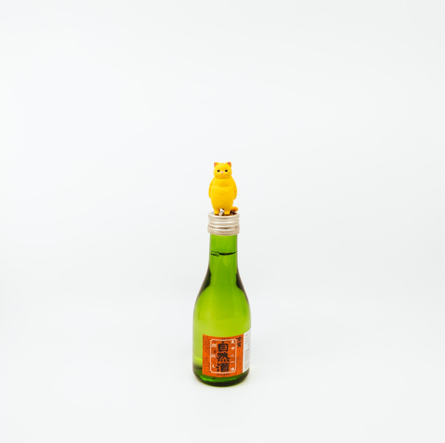 small green bottle with cat figurine on top