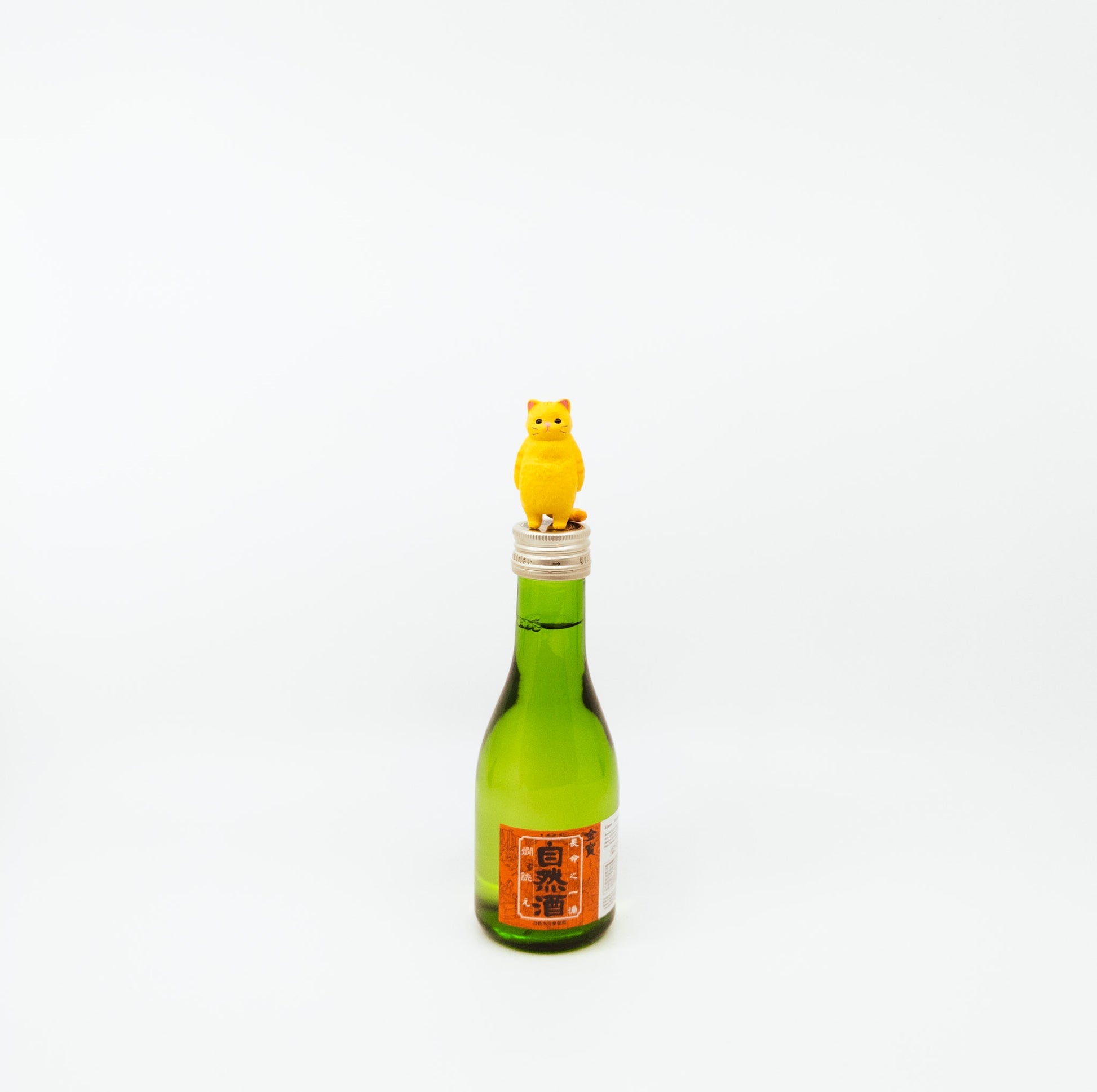 small green bottle with cat figurine on top